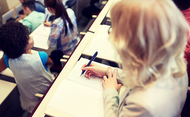 Image showing student writing to notebook at exam or lecture