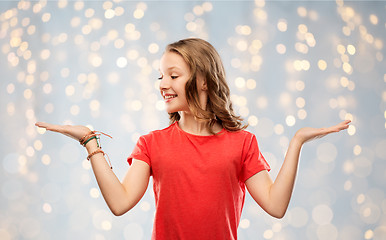 Image showing smiling teenage girl holding empty hand