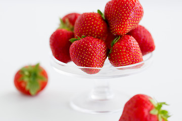 Image showing strawberries on glass stand over white background