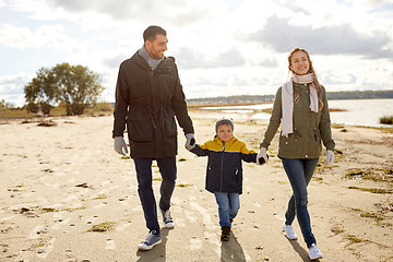 Image showing happy family walking along autumn beach