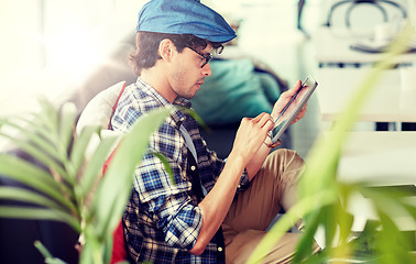 Image showing man with tablet pc sitting at cafe table