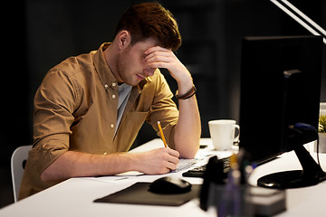 Image showing man with notepad working late at night office