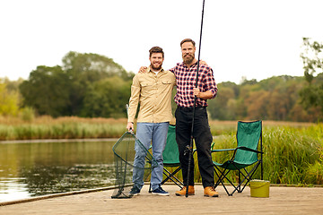 Image showing friends with fishing rod and net at lake or river