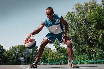 Image showing Picture of young confused african basketball player practicing