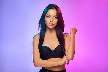 Image showing High Fashion model woman in colorful bright lights posing in studio