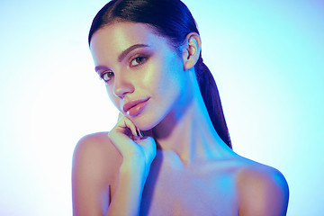 Image showing High Fashion model woman in colorful bright lights posing in studio