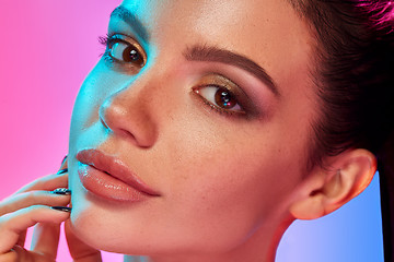 Image showing High Fashion model woman in colorful bright lights posing in studio