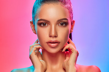 Image showing High Fashion model woman in colorful bright lights posing in studio