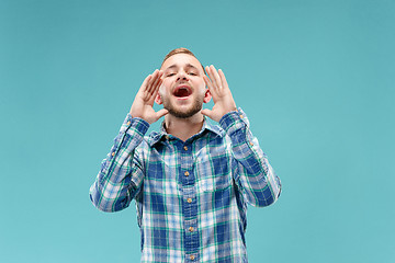 Image showing Isolated on pink young casual man shouting at studio