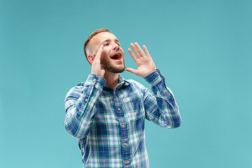 Image showing Isolated on pink young casual man shouting at studio