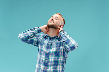 Image showing The happy businessman standing and smiling against blue background.