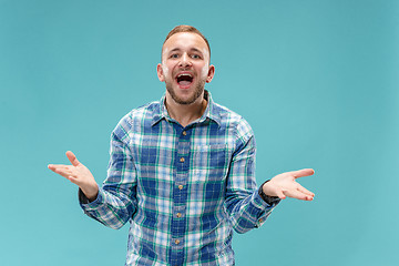 Image showing Beautiful male half-length portrait isolated on blue studio backgroud.