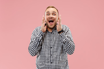 Image showing The young attractive man looking suprised isolated on pink