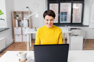 Image showing happy businesswoman with laptop working at office