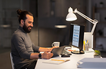 Image showing creative man with computer working at night office