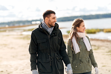 Image showing happy couple at autumn beach holding hands