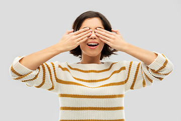 Image showing happy smiling woman closing her eyes by hands