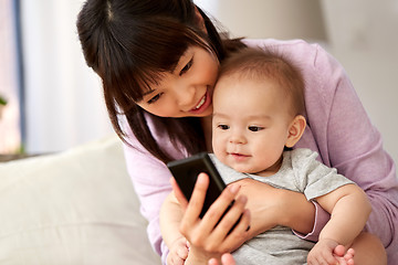 Image showing asian mother with baby son taking selfie at home