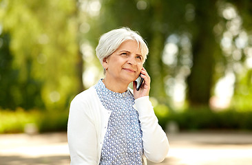 Image showing senior woman calling on smartphone in summer park