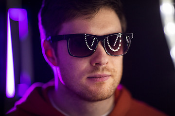 Image showing man in sunglasses over ultra violet neon lights