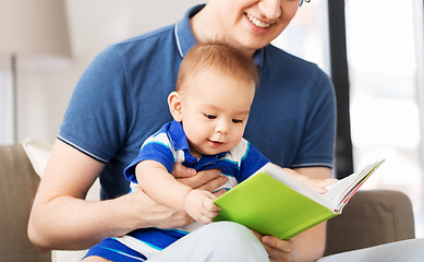 Image showing happy father and little baby son with book at home