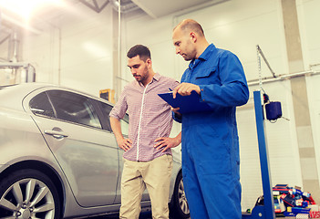 Image showing auto mechanic with clipboard and man at car shop