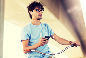 Image showing man with smartphone and earphones on bicycle