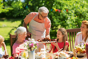 Image showing family having dinner or barbecue at summer garden