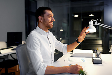 Image showing businessman using gestures at night office