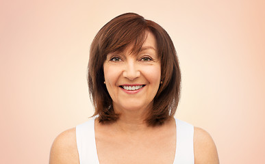 Image showing portrait of smiling senior woman over beige