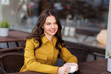 Image showing teenage girl drinking hot chocolate at city cafe