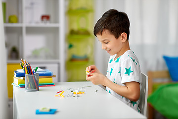 Image showing little boy playing with building kit at home