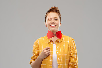 Image showing smiling red haired teenage girl with big bowtie