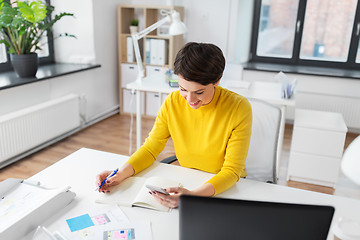 Image showing smiling ui designer using smartphone at office