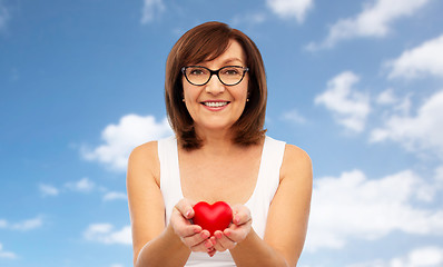 Image showing portrait of smiling senior woman holding red heart