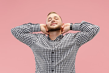 Image showing The happy businessman standing and smiling against pink background.