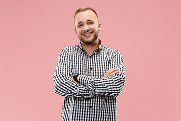 Image showing The happy business man standing and smiling against pink background.