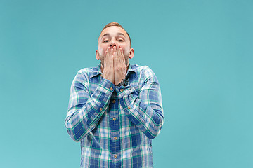 Image showing The young attractive man looking suprised isolated on blue