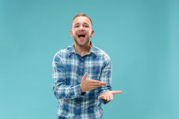 Image showing Beautiful male half-length portrait isolated on blue studio backgroud.