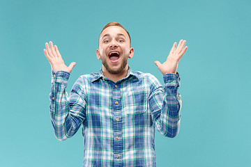 Image showing The young attractive man looking suprised isolated on blue