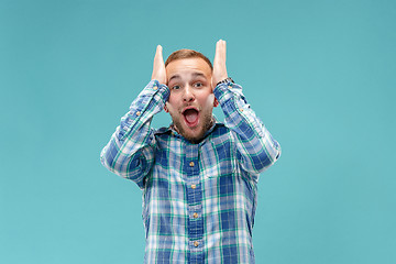 Image showing The young attractive man looking suprised isolated on blue