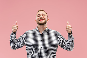 Image showing The happy businessman standing and smiling against pink background.