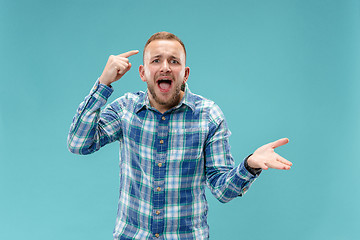 Image showing Beautiful male half-length portrait isolated on blue studio backgroud.