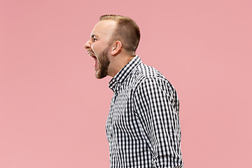 Image showing The young emotional angry man screaming on studio background