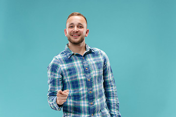 Image showing The happy business man point you and want you, half length closeup portrait on blue background.