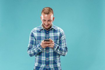 Image showing Young handsome man talking over phone and looking away.