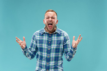 Image showing The young emotional angry man screaming on studio background