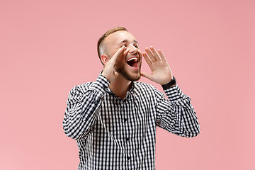 Image showing Isolated on pink young casual man shouting at studio