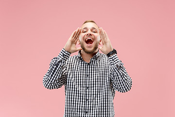 Image showing Isolated on pink young casual man shouting at studio