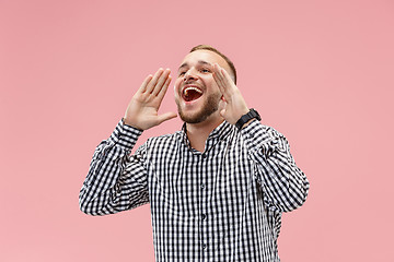 Image showing Isolated on pink young casual man shouting at studio